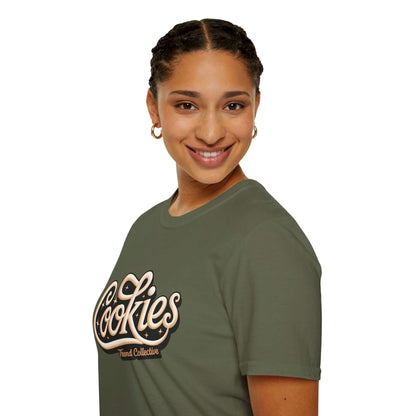 Smiling woman wearing a trendy Cookies Trend Collective T-Shirt in olive green with stylish cursive writing.