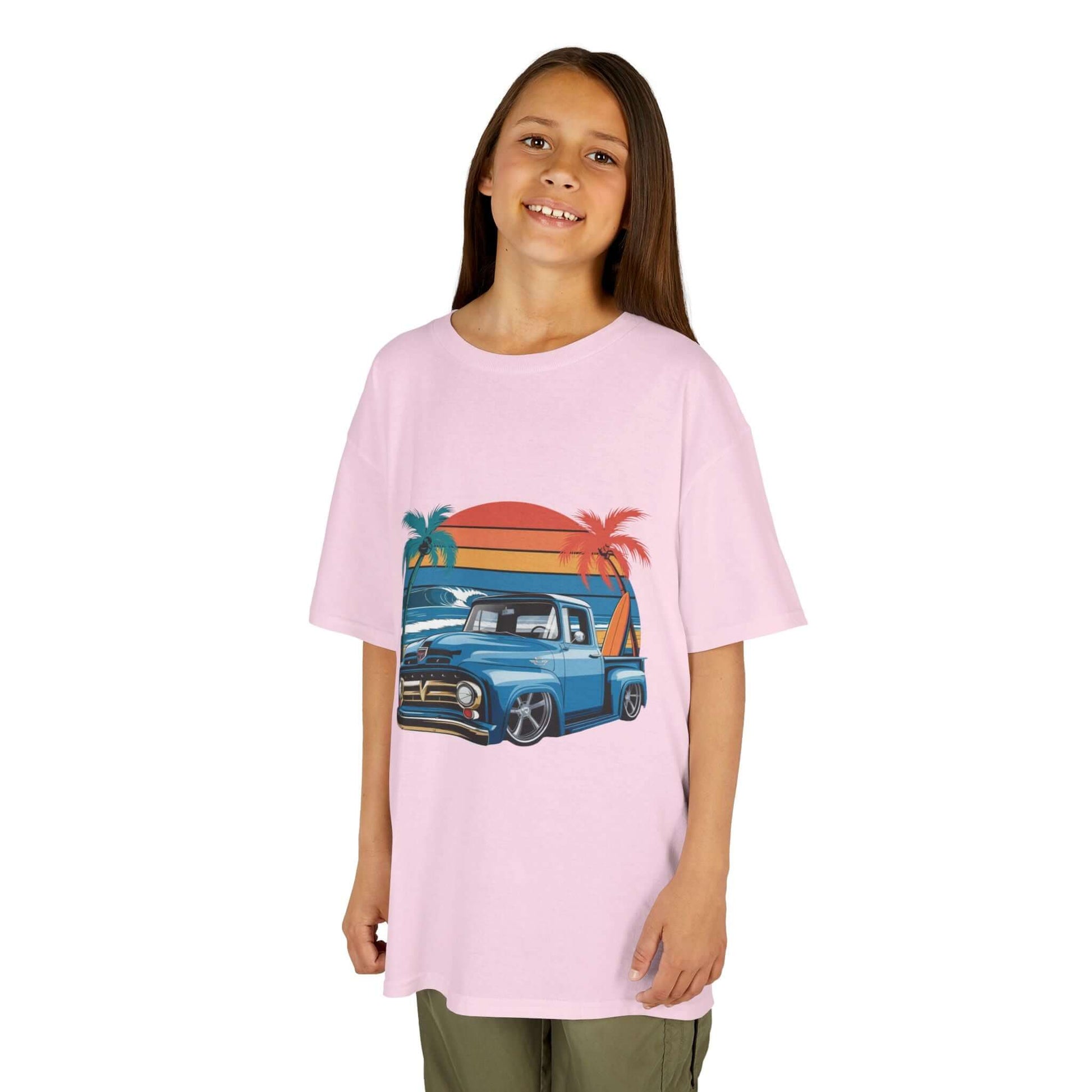 Girl wearing a pink retro kids t-shirt with vintage pickup truck design, perfect for cruisin vibes and summer fun.
