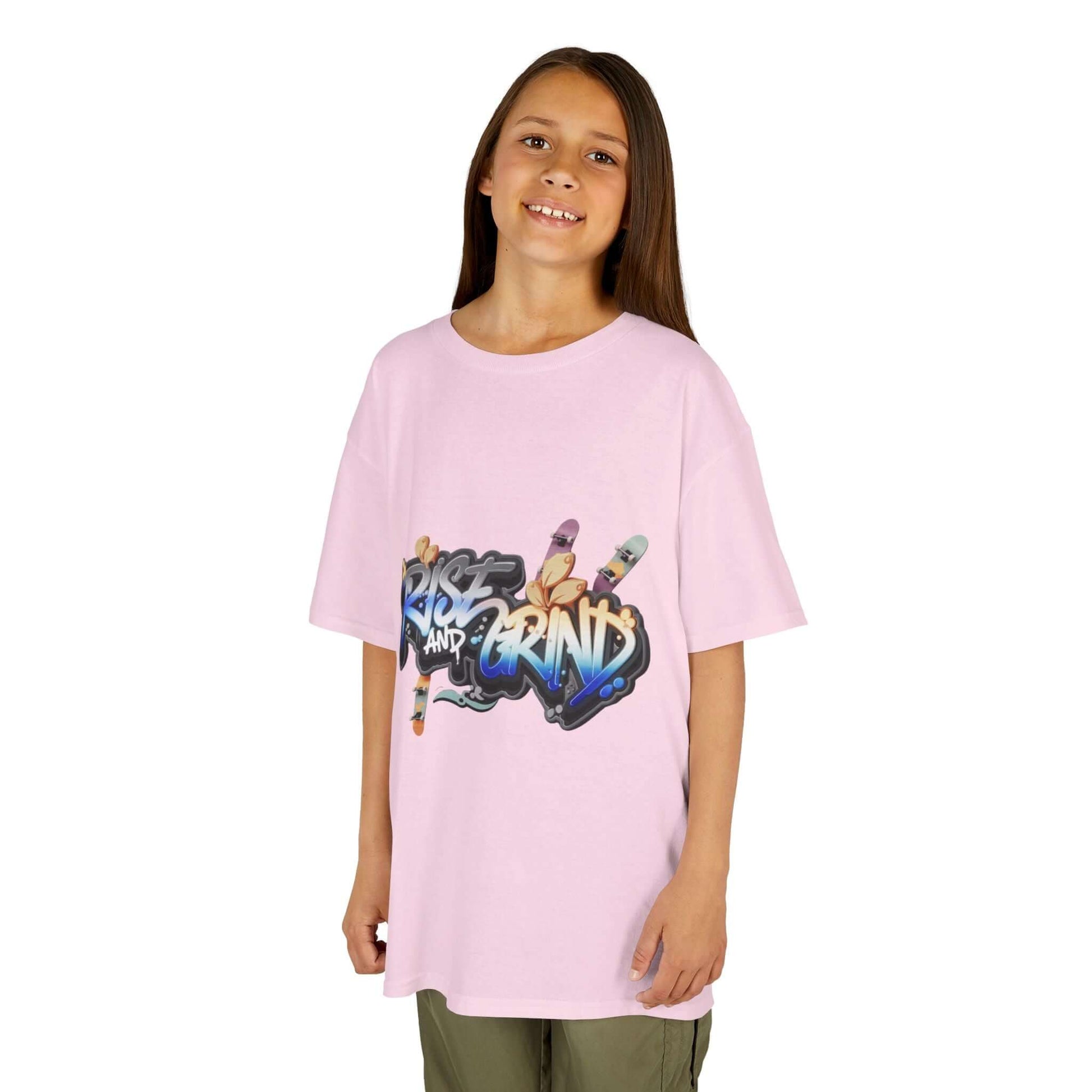Kid's T-shirt in pink with graffiti 'Rise and Grind' design, featuring skateboards and urban style.