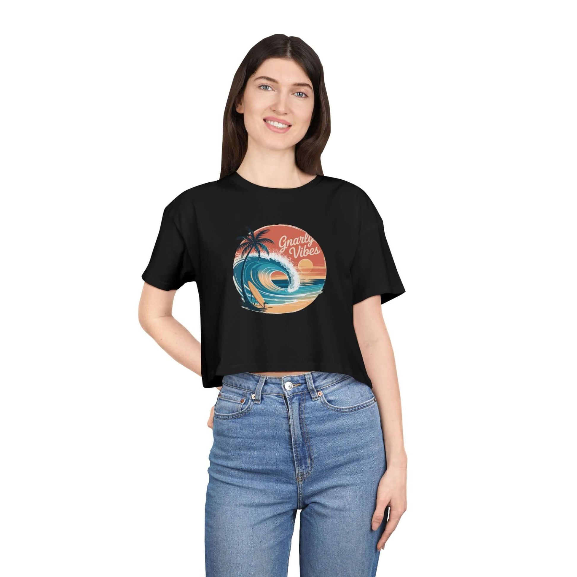 Women's crop top with retro big wave surf design and 'Gnarly Vibes' on a sunset beach backdrop.