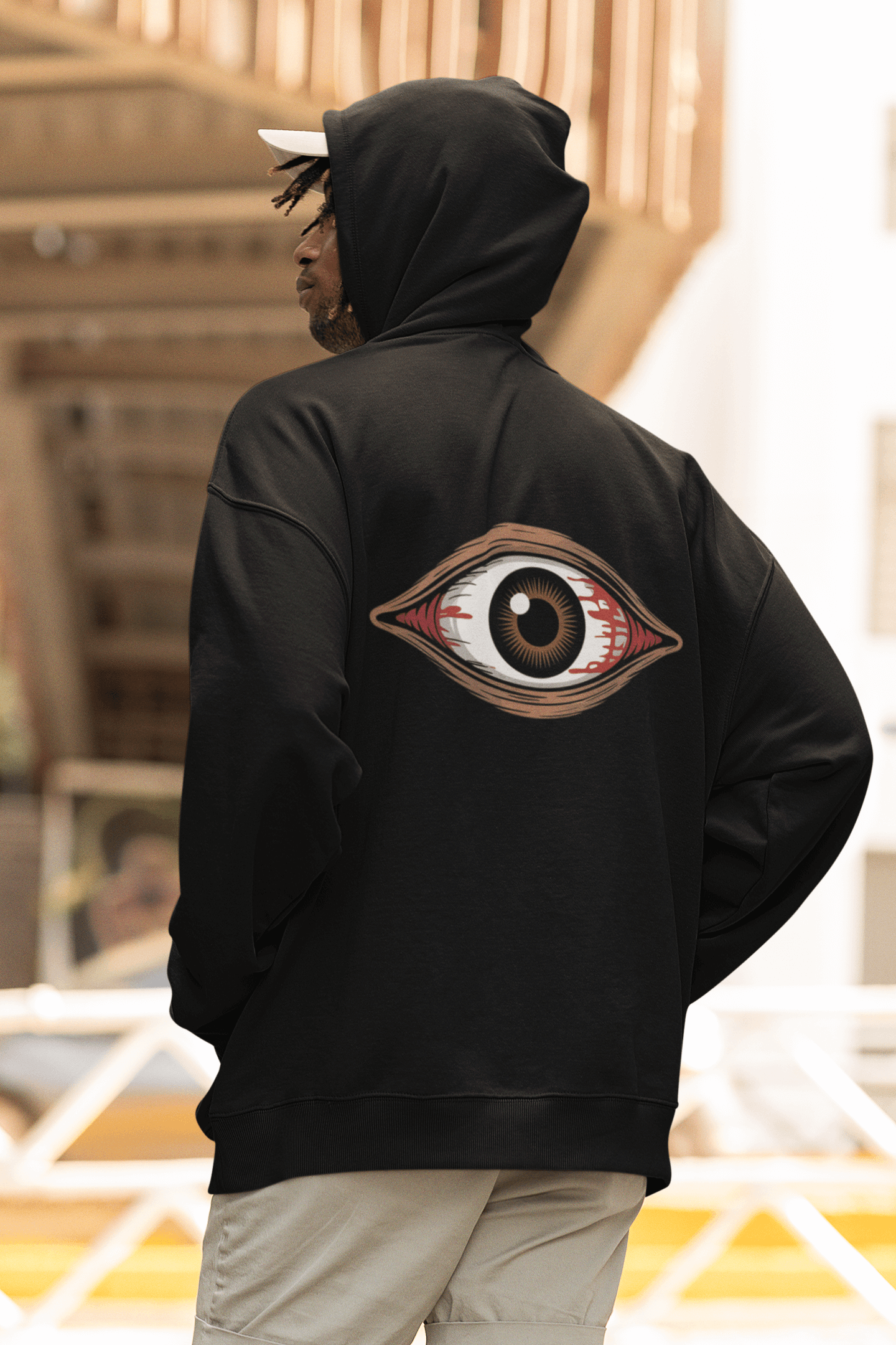 Back view of a unisex black hoodie featuring a spooky bloody brown eye design, perfect for music festivals and Halloween.