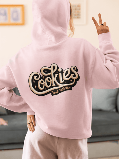 Cozy pink hoodie with vintage 'Cookies Trend Collective' hand-lettered design, perfect for retro fashion lovers.