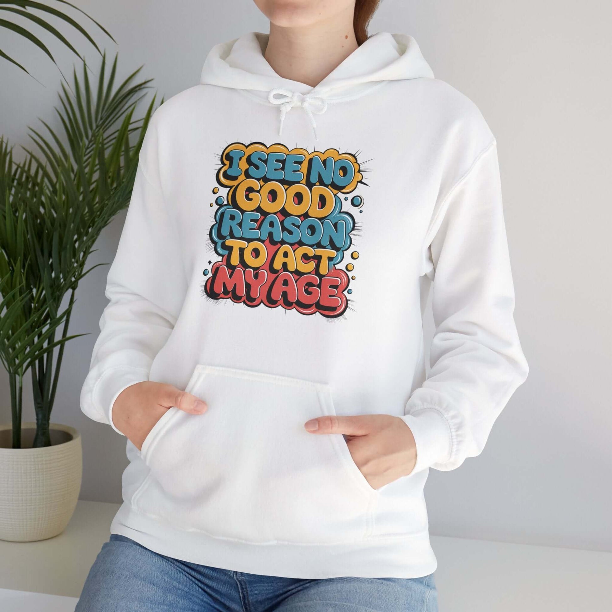 Colorful hoodie with funny quote 'I see no good reason to act my age', featuring spacious pockets and drawstring hood.