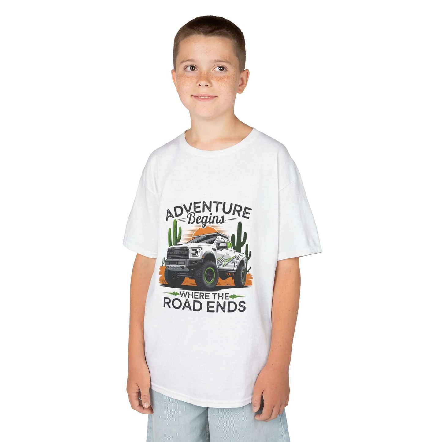 Kids T-shirt featuring off road truck in a sunset desert with text 'Adventure begins where the road ends'.